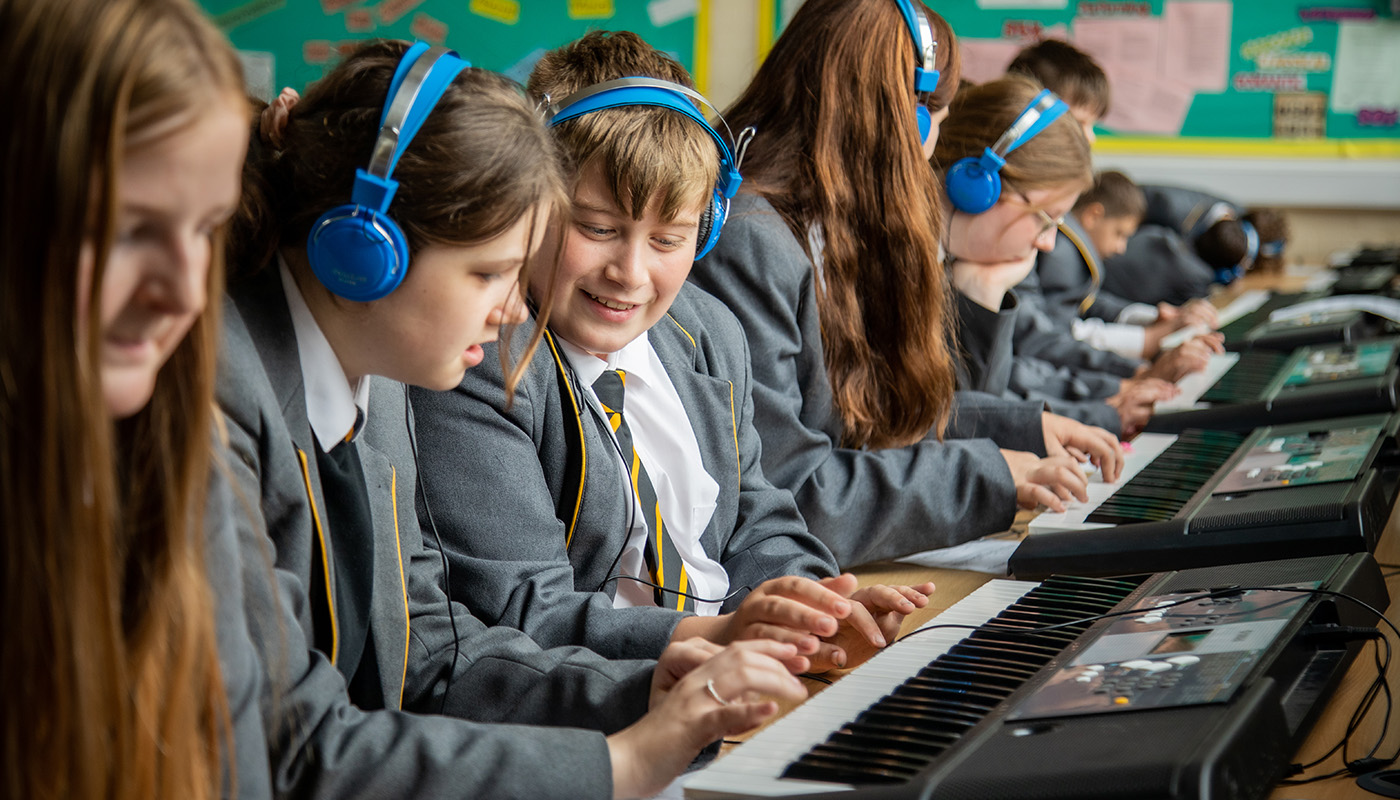 Children in a classroom with headphones making music