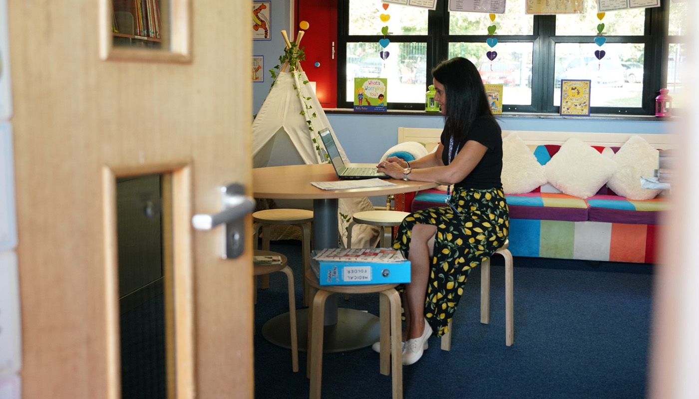 A teacher sitting at her computer