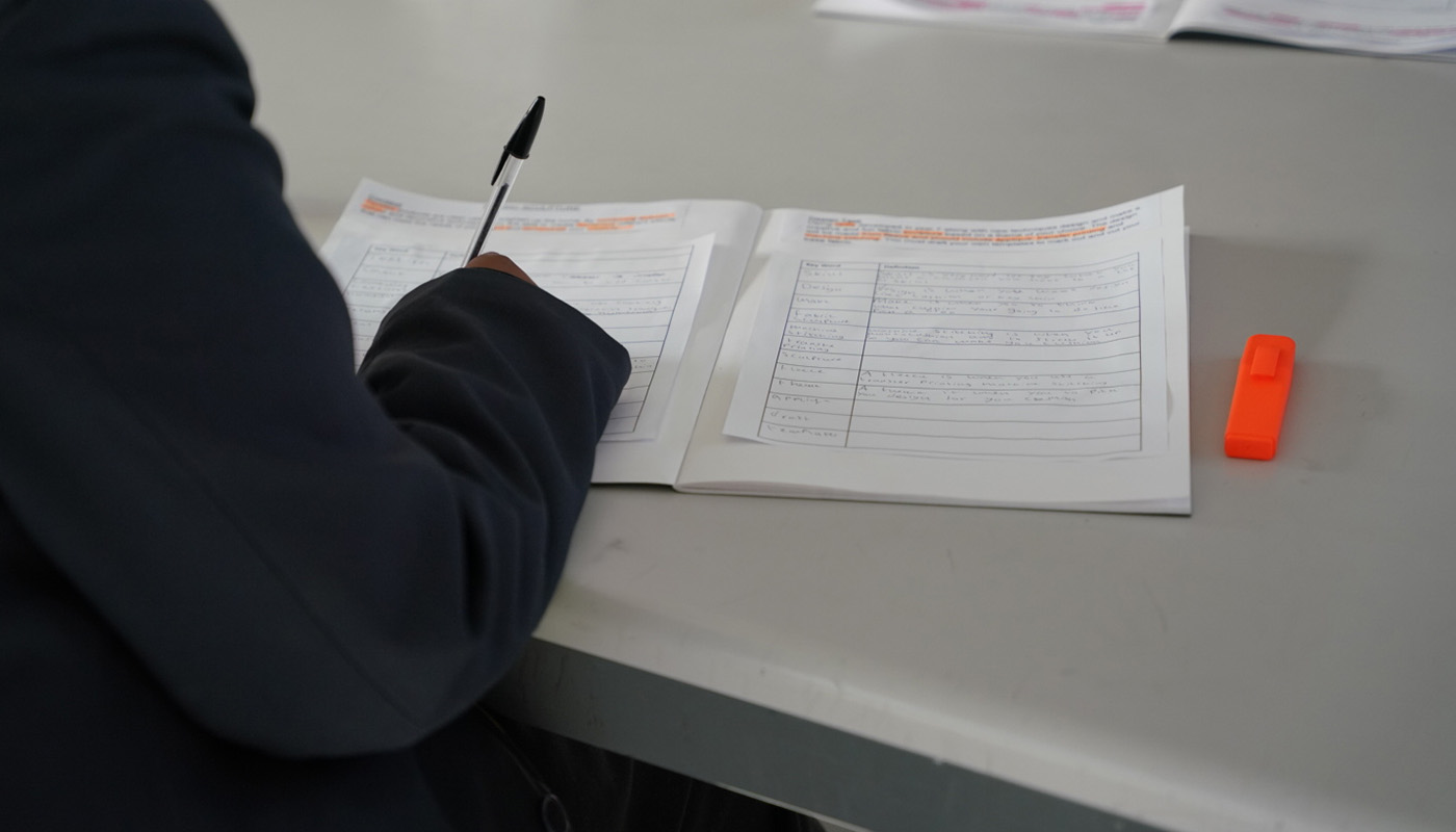 Pupil writing at a desk