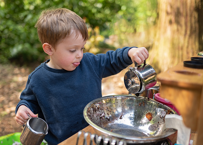 A child playing with cooking toys outside