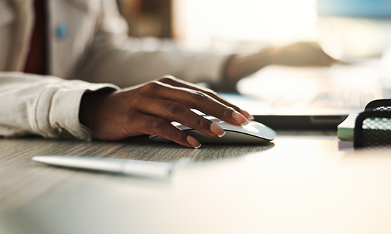 A close up of a hand using a mouse