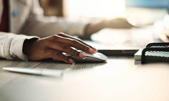 Close-up of a hand using a computer mouse