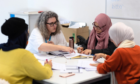 Four women sitting around a table working