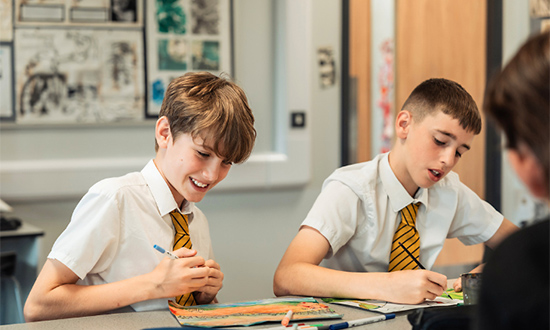 Two male students working at their desks