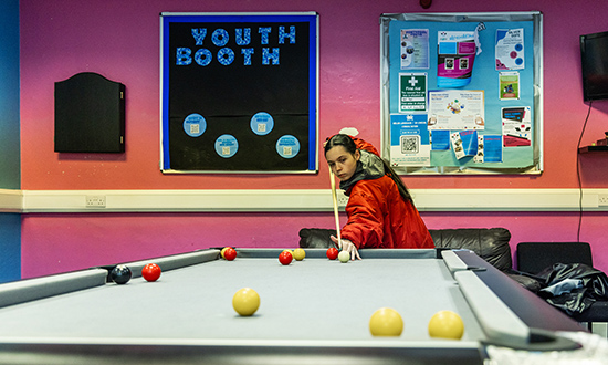 A young woman taking a shot at a pool table