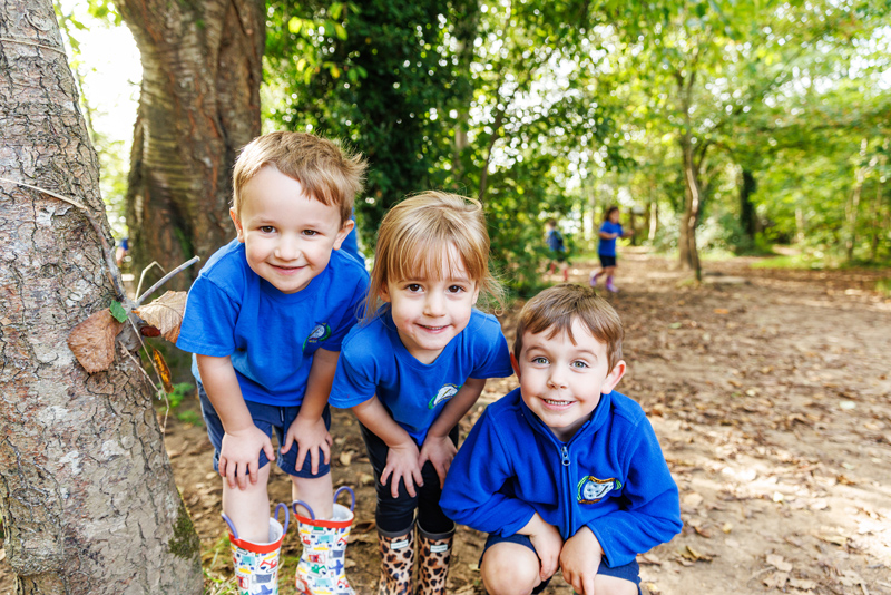 Three children smiling outside