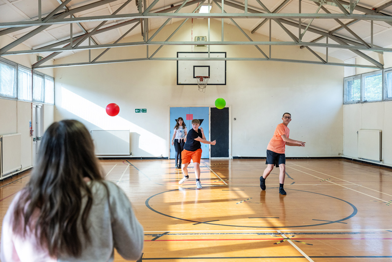 Young people playing sports in a hall